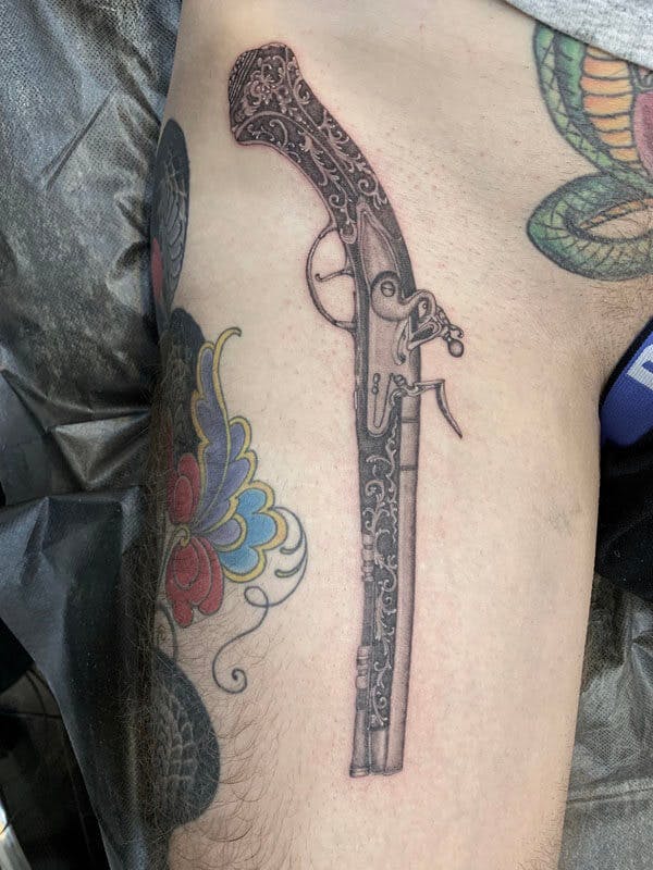14Matt-black and gray realistic musket tattoo on arm